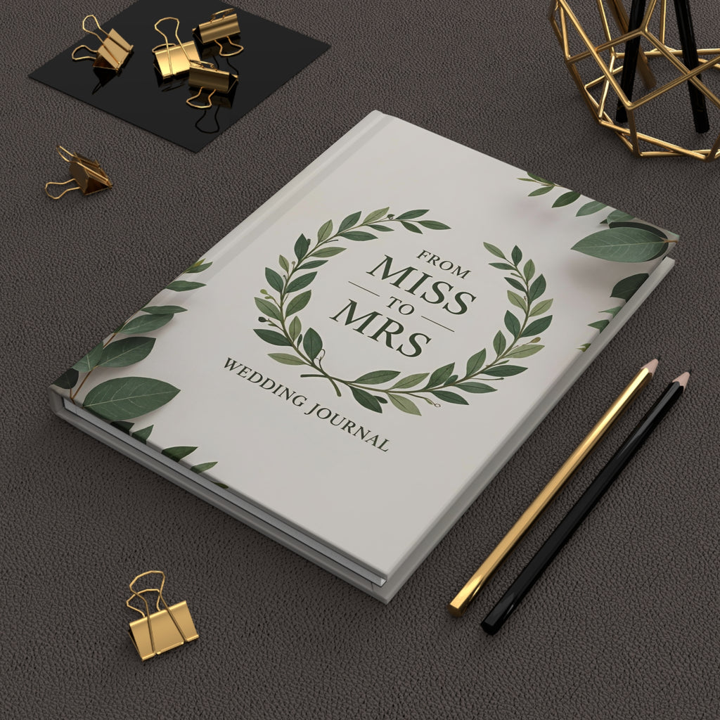 Wedding journal titled 'From Miss to Mrs' on a dark surface with stationery items.
