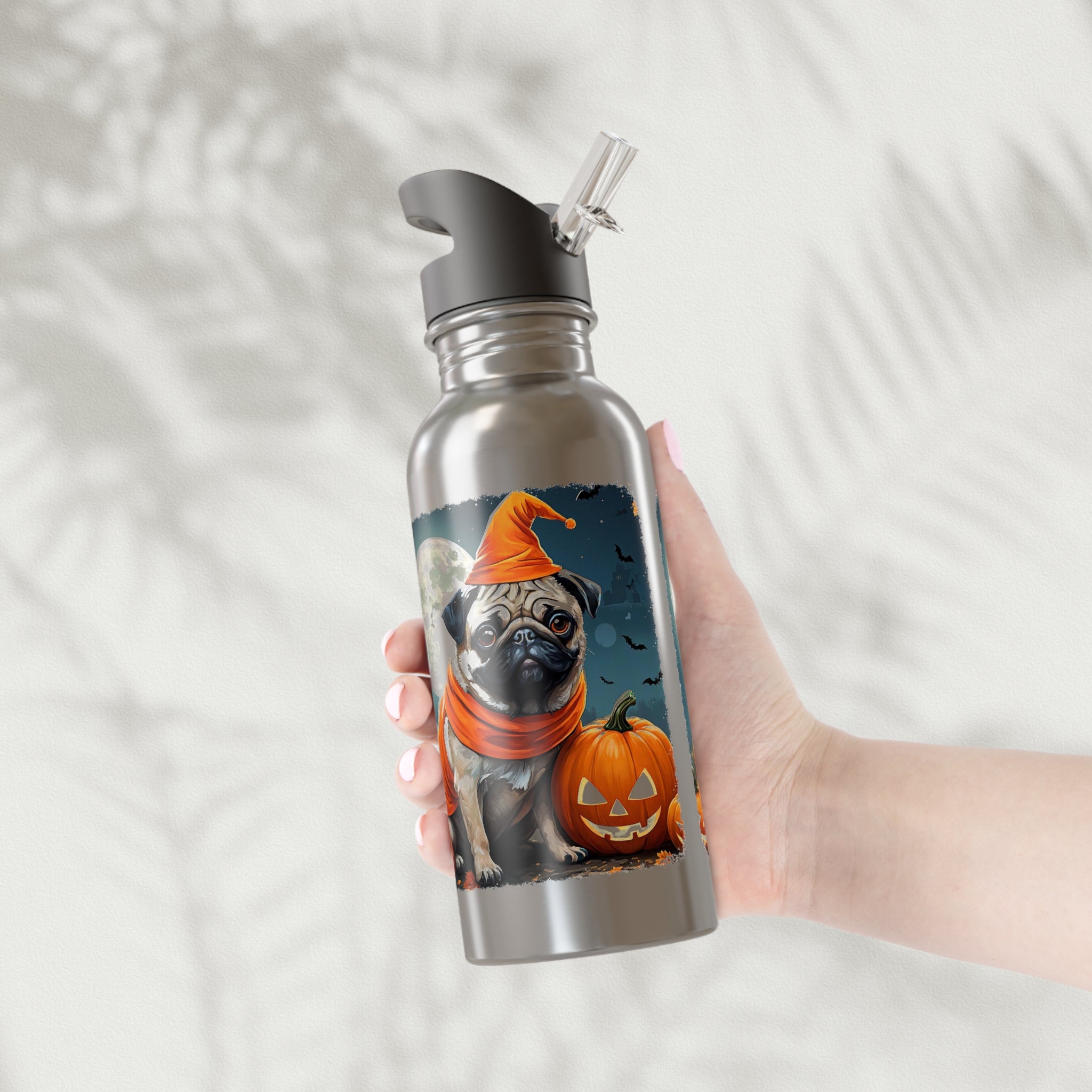 Hand holding a stainless steel water bottle with a Halloween-themed design of a pug and pumpkin.