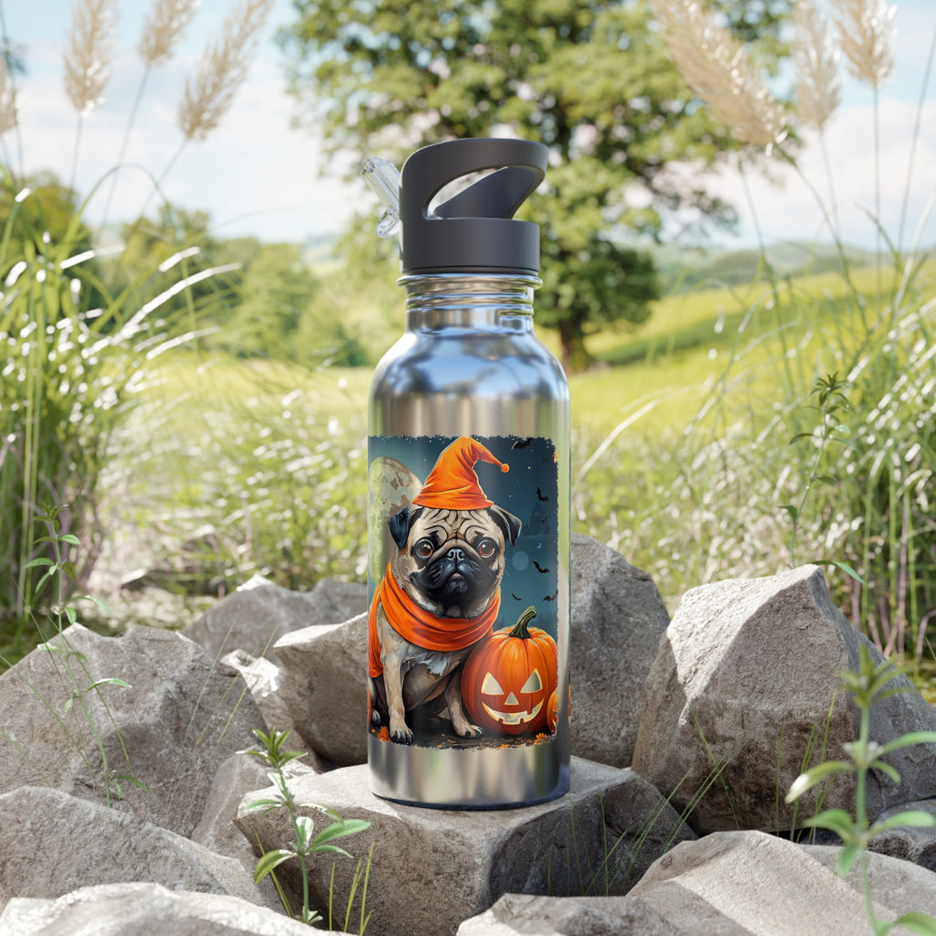 Metal water bottle with a dog and pumpkin design on a rocky surface with grass and trees in the background