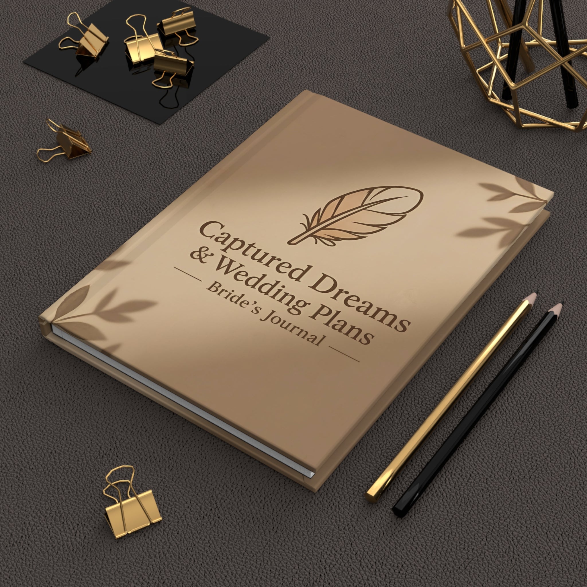 Beige journal titled 'Captured Dreams & Wedding Plans' with decorative elements on a dark surface.